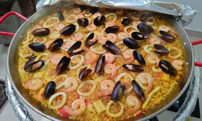 Deliciosa paella de mariscos con camarones, calamares, mejillones y arroz tradicional, preparada con ingredientes frescos y de calidad.